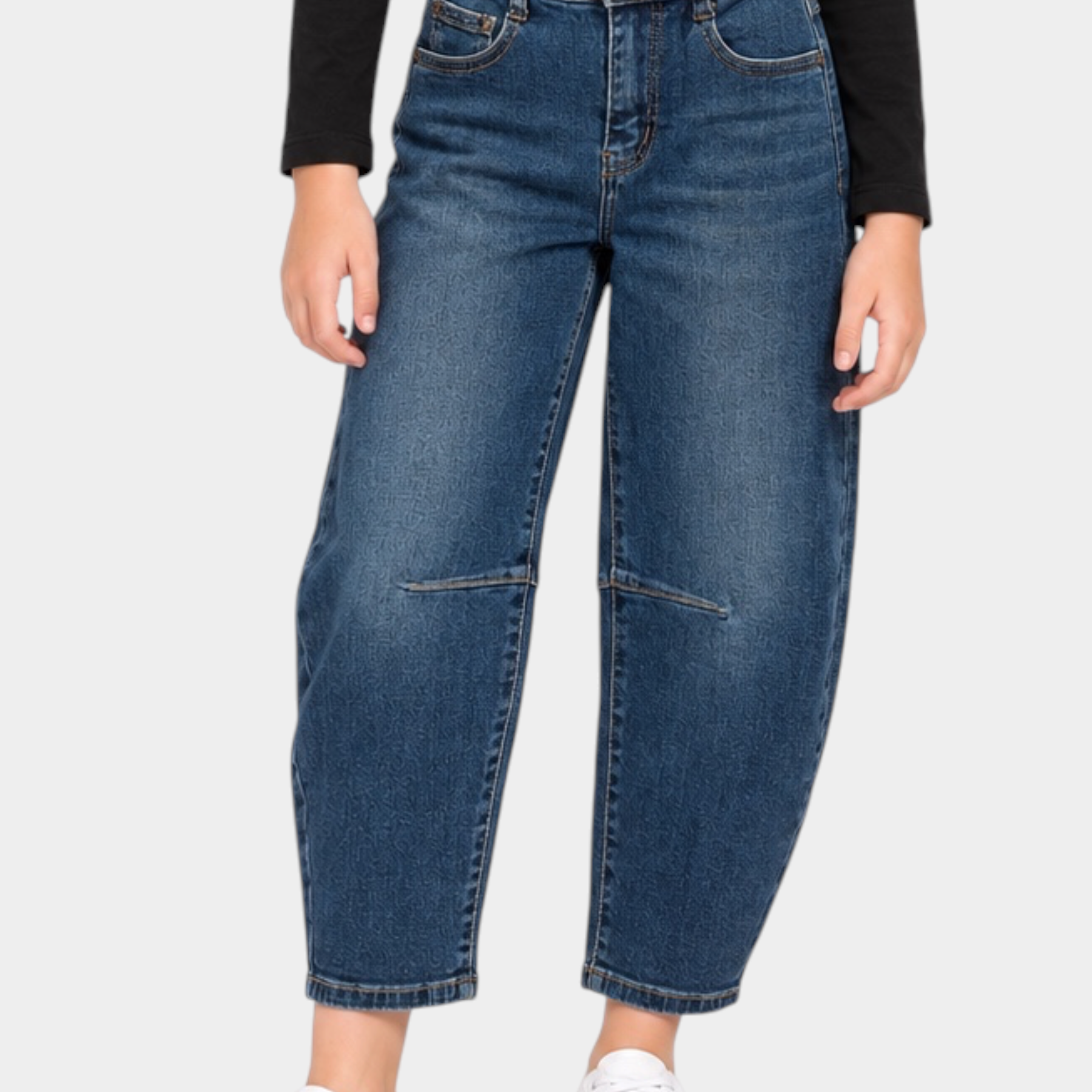 Ragazza che indossa jeans baggy blu Follower SRL con maglia nera a maniche lunghe e scarpe da ginnastica bianche