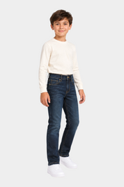 Bambino indossa jeans regular fit blu scuri US GRAND POLO di Follower SRL con maglia a maniche lunghe panna
