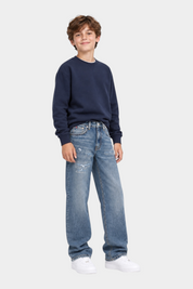 Ragazzo indossa jeans barrel fit Follower SRL Tommy Hilfiger blu con effetto vintage e felpa blu scuro
