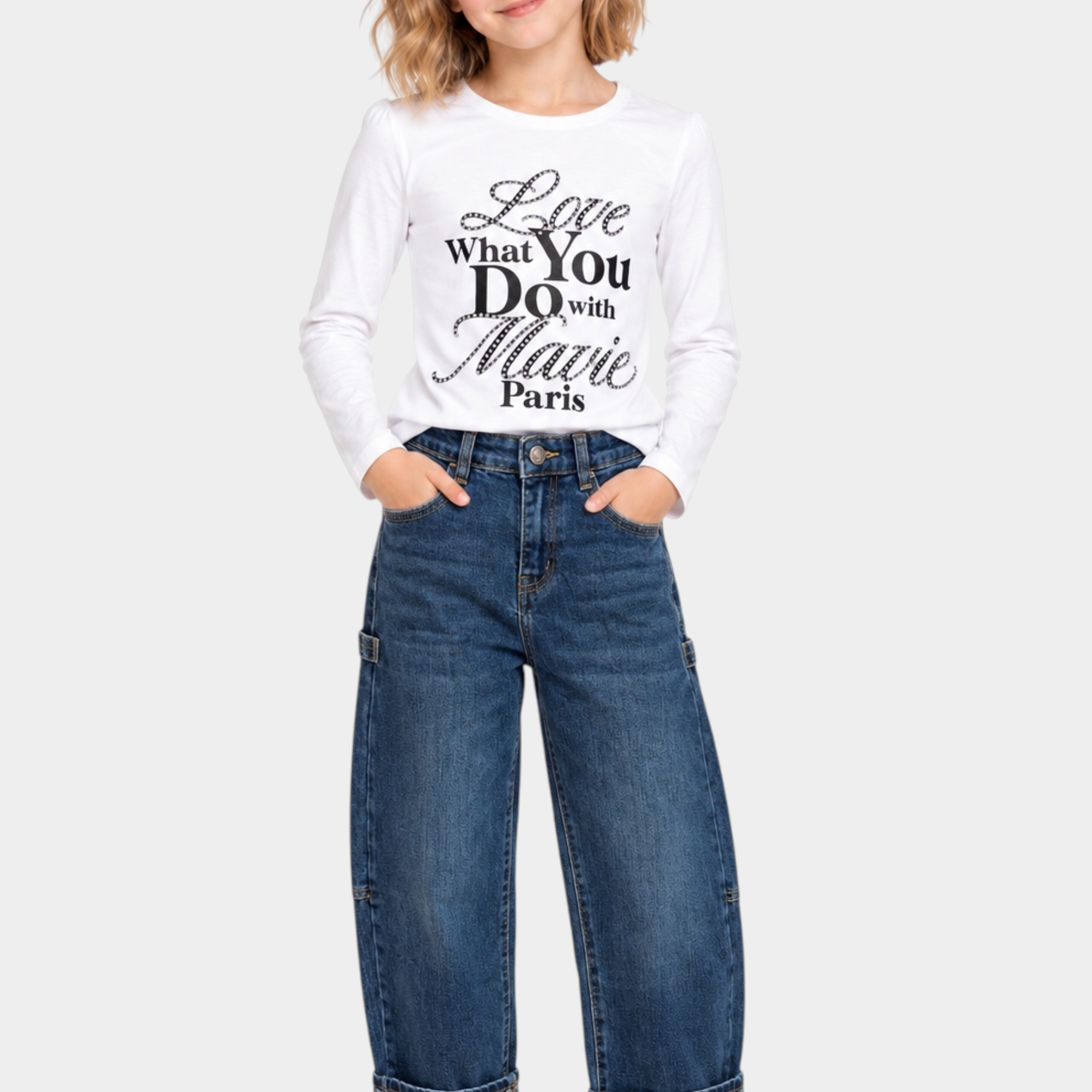 Bambina indossa jeans carpenter a gamba larga blu Follower SRL con risvolto, abbinati a maglia bianca a maniche lunghe