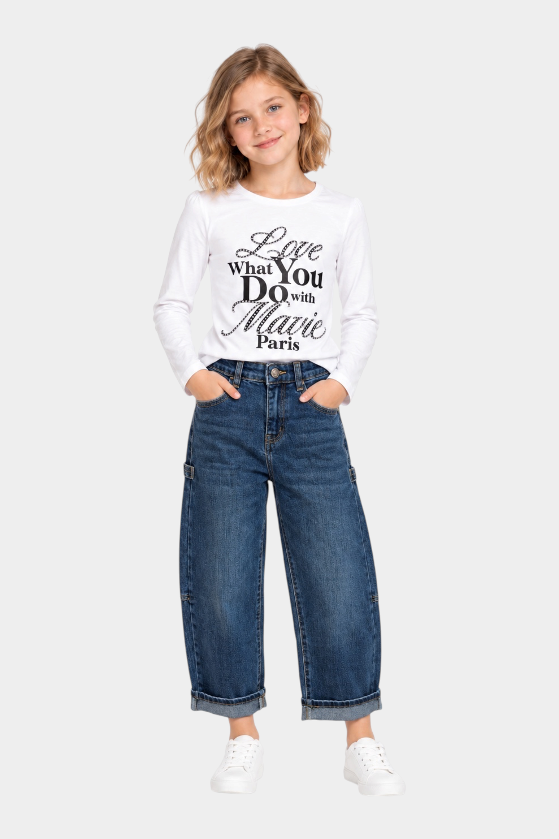 Bambina indossa jeans carpenter a gamba larga blu Follower SRL con risvolto, abbinati a maglia bianca a maniche lunghe
