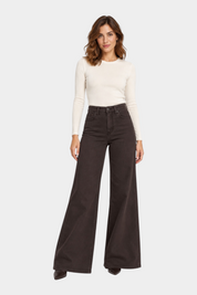 Modella indossa jeans a gamba larga marroni Follower SRL abbinati a un maglione a maniche lunghe color crema