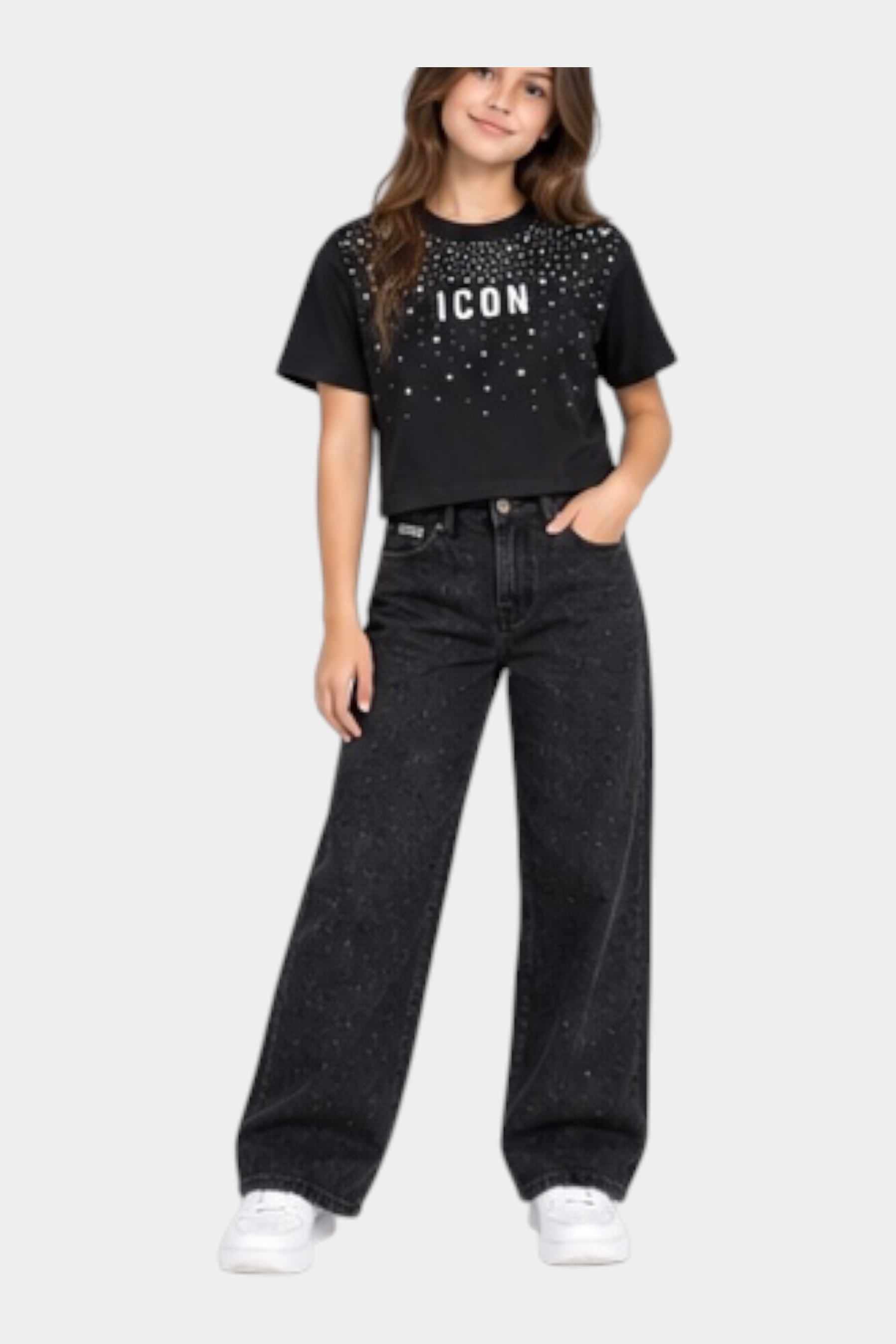 Ragazza indossa jeans larghi neri con strass e t-shirt nera ICON Follower SRL su sfondo neutro