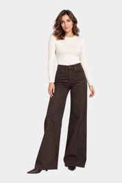 Modella indossa jeans a gamba larga marroni Follower SRL abbinati a un maglione a costine color crema