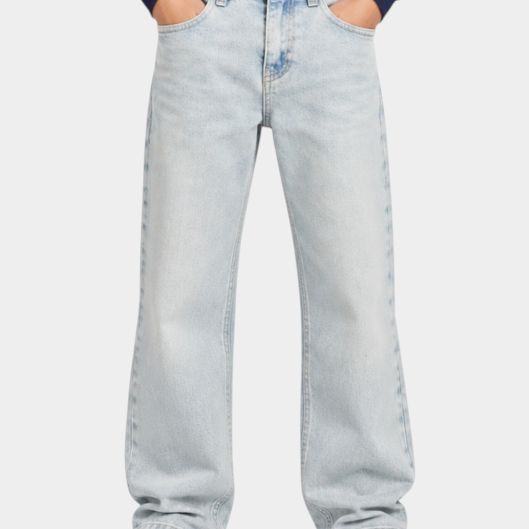 Ragazzo indossa jeans skater fit azzurri Calvin Klein di Follower SRL con felpa blu e scarpe da ginnastica bianche