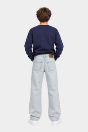 Ragazzo indossa jeans skater fit azzurri Follower SRL con logo iconico Calvin Klein e felpa blu scuro