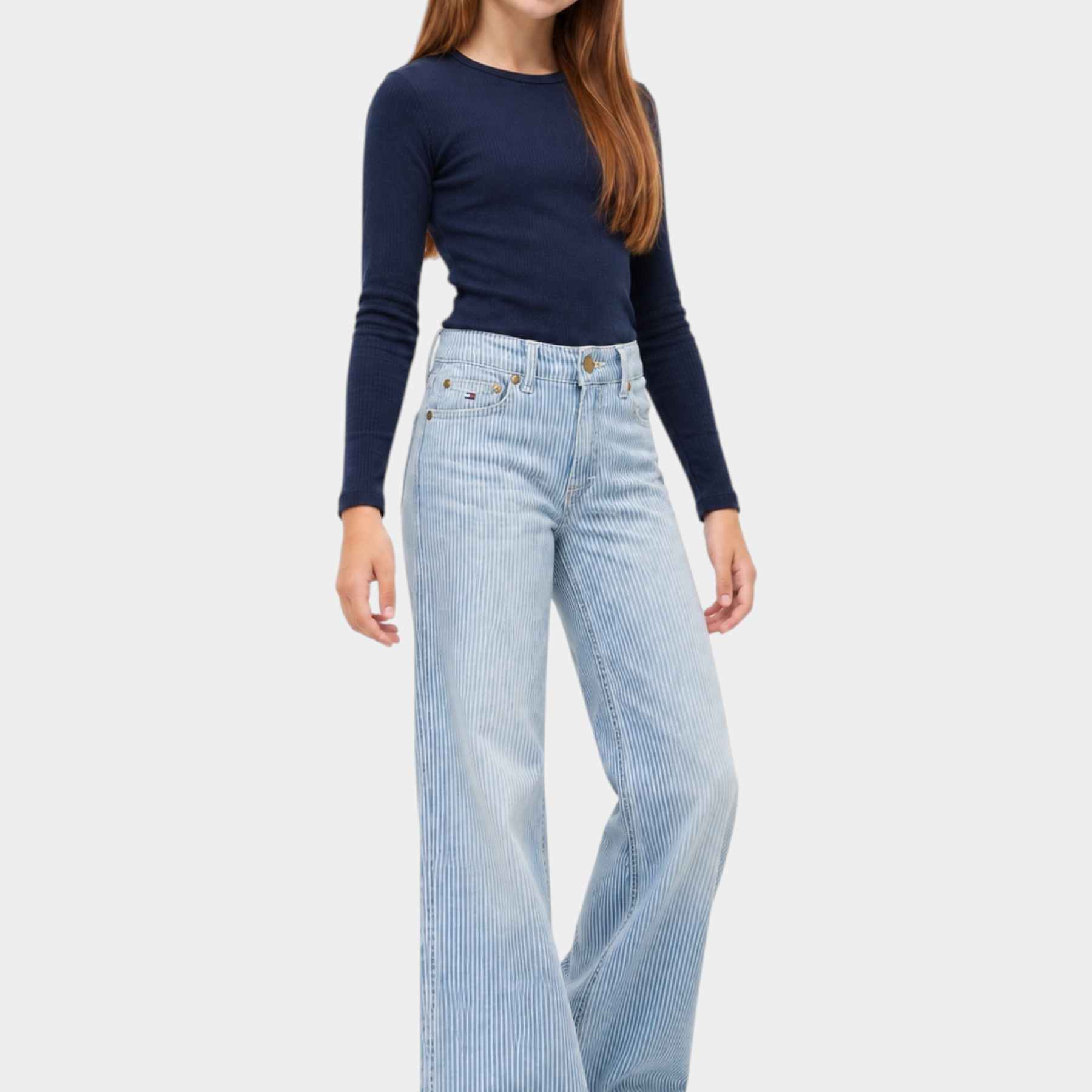 Ragazza indossa jeans wide leg a righe azzurri Follower SRL con maglia blu a maniche lunghe e scarpe bianche
