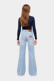 Ragazza indossa jeans wide leg a righe azzurre Follower SRL con logo Tommy Hilfiger ricamato sulla tasca posteriore