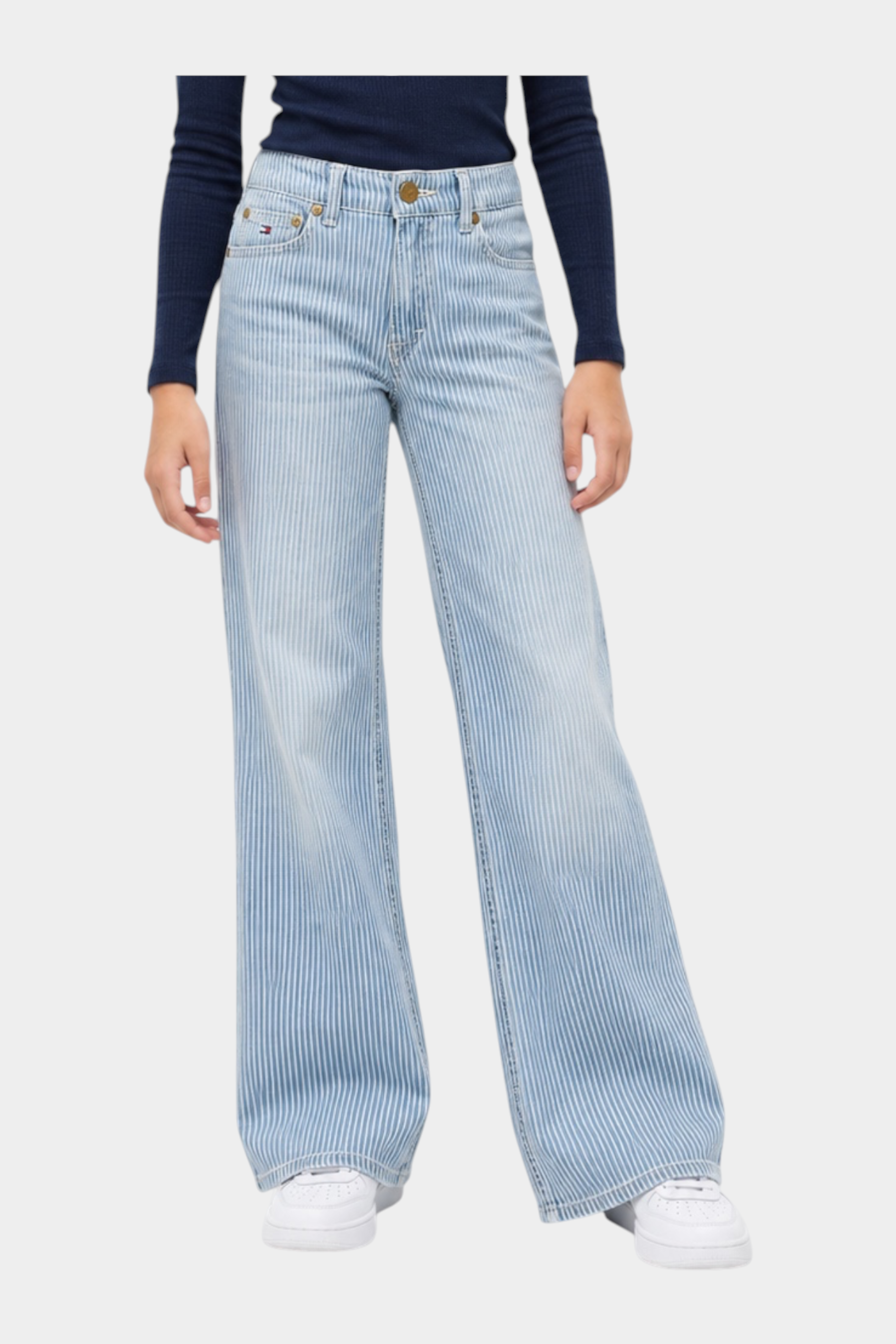 Ragazza indossa jeans wide leg a righe azzurri TOMMY HILFIGER di Follower SRL con maglia blu a maniche lunghe