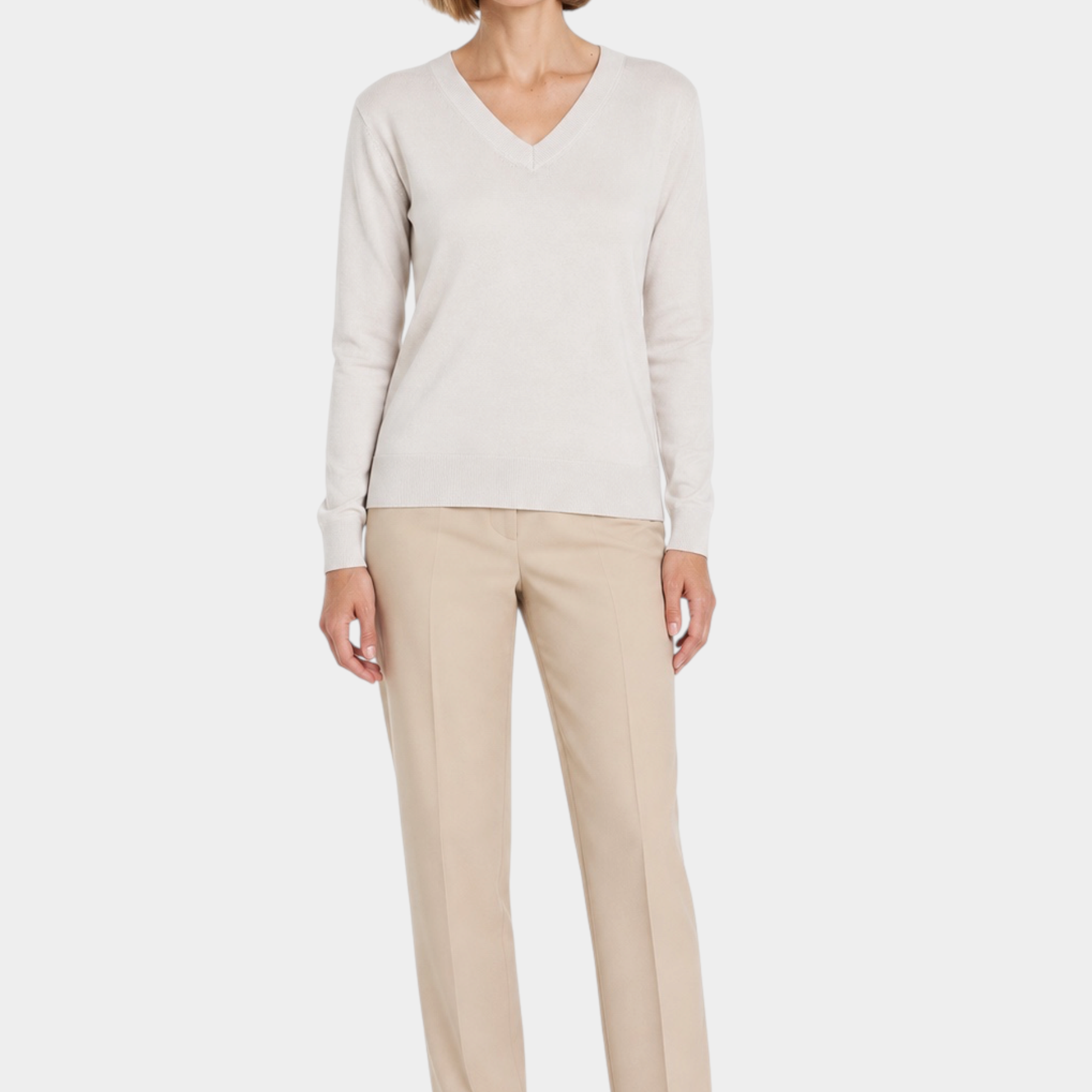 Modella indossa maglia Follower SRL Ragno color avorio con scollo a V, abbinata a pantaloni beige e mocassini