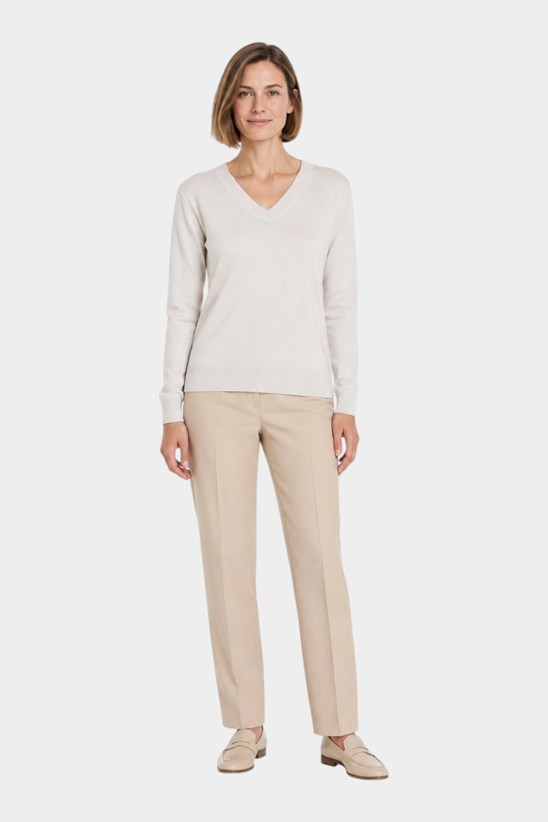 Modella indossa maglia Follower SRL Ragno color avorio con scollo a V, abbinata a pantaloni beige e mocassini