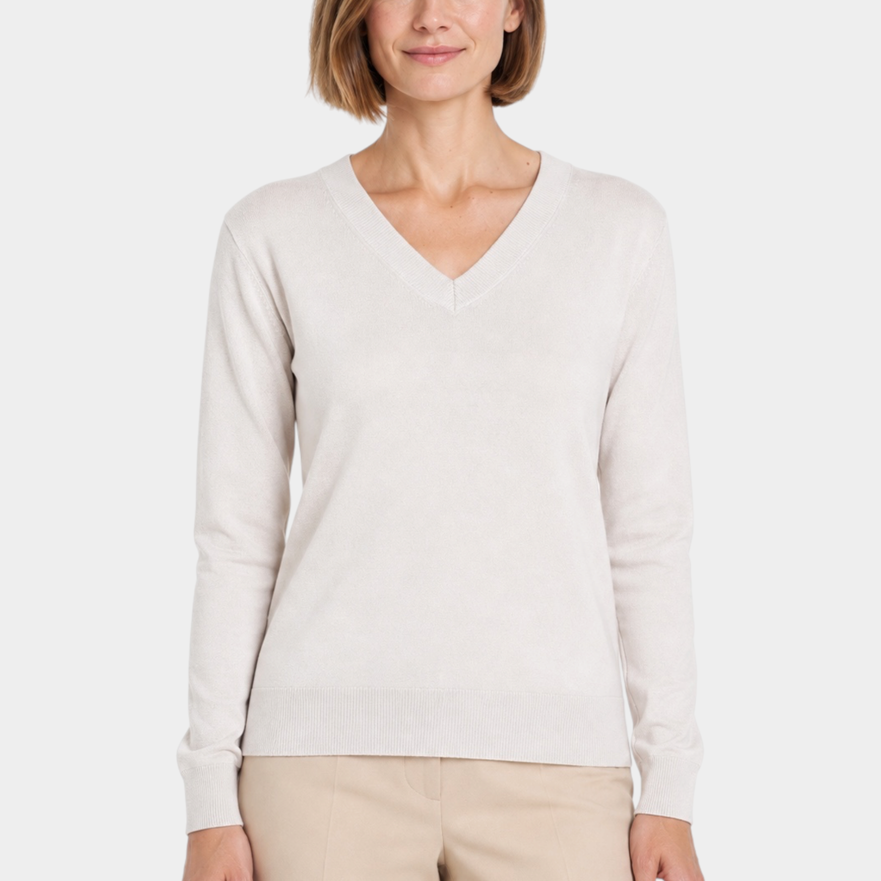 Donna che indossa una maglia Follower SRL color avorio con scollo a V e maniche lunghe su sfondo bianco