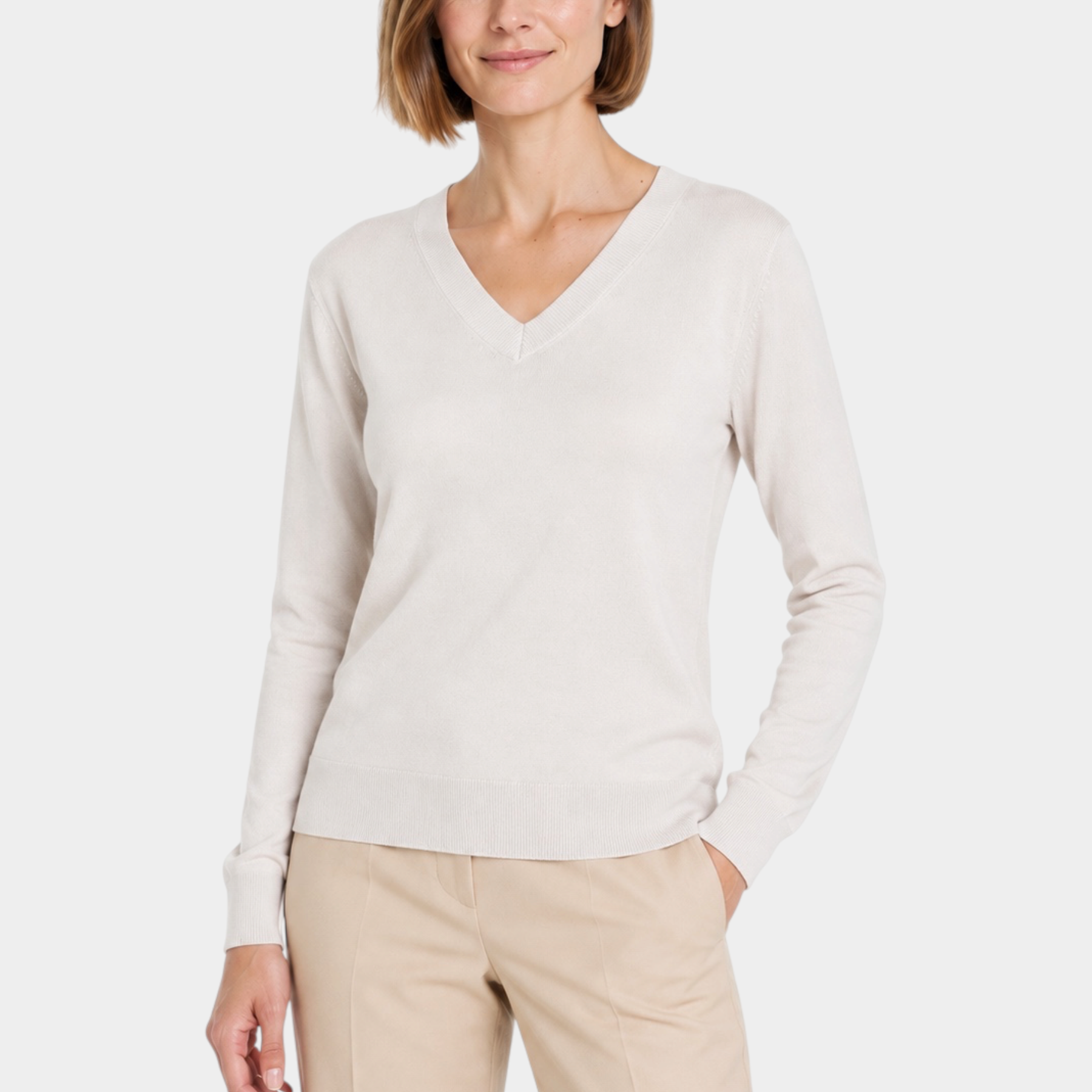 Modella indossa maglia avorio con scollo a V Ragno, design elegante e minimalista per un look casual chic
