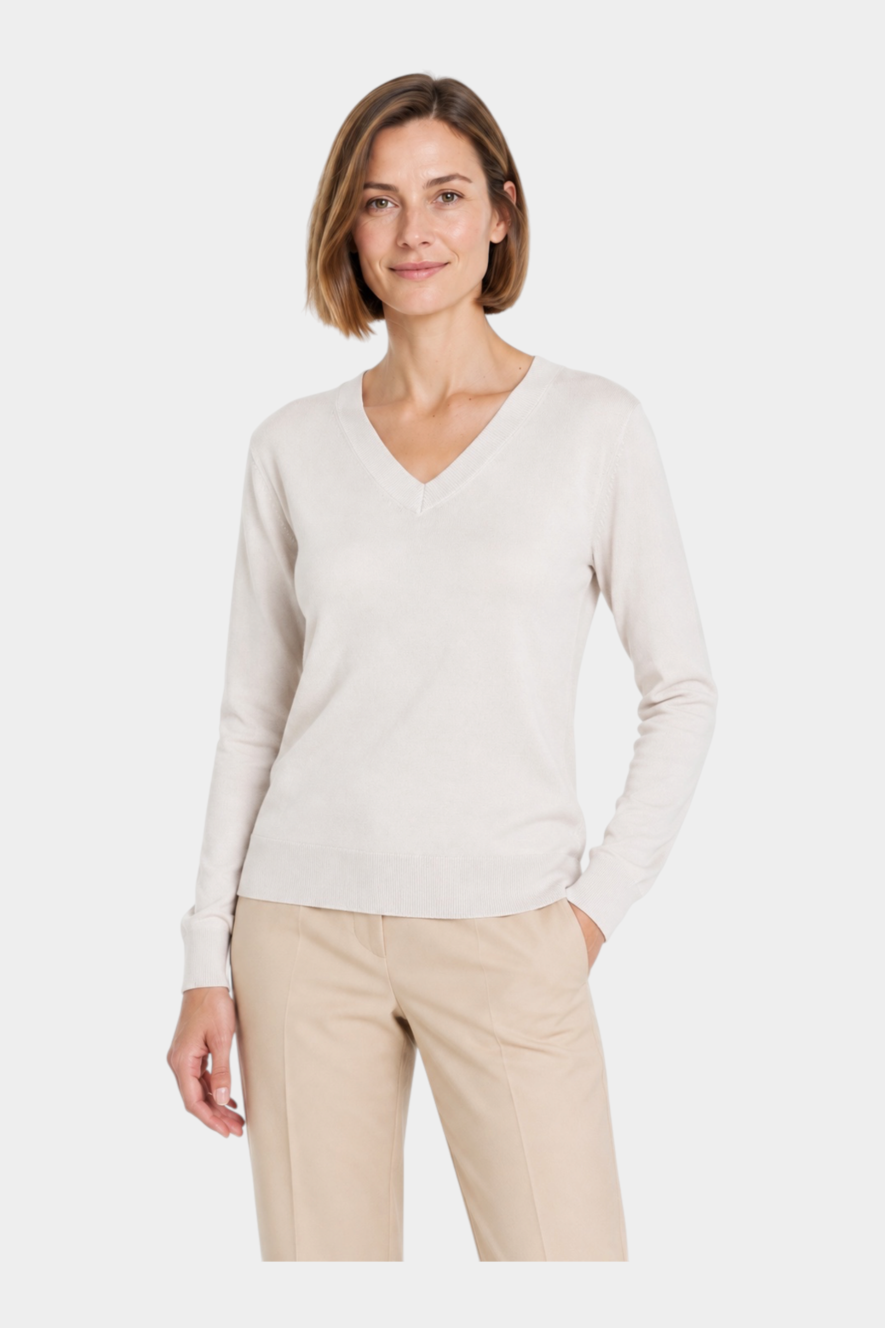 Modella indossa maglia avorio con scollo a V Ragno, design elegante e minimalista per un look casual chic