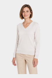 Modella indossa una maglia Follower SRL color avorio con scollo a V, maniche lunghe e vestibilità classica