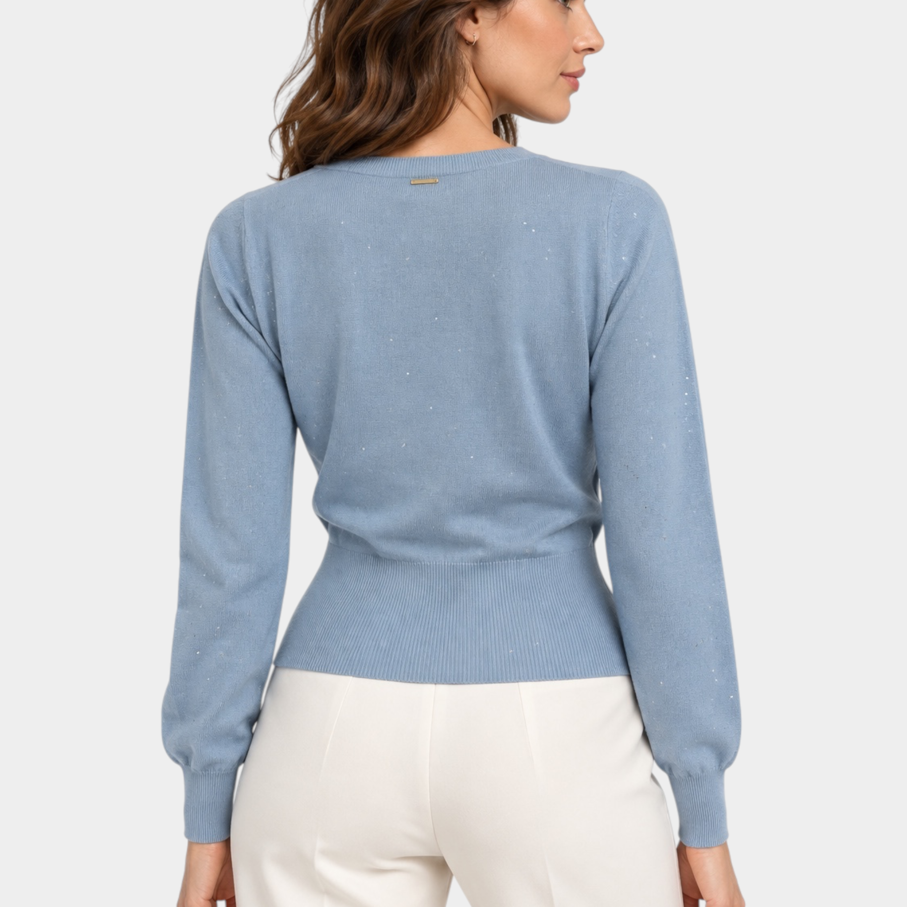 Modella indossa maglia Follower SRL azzurra a maniche lunghe con paillettes e scollo a V, vista posteriore