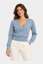 Modella indossa maglia Follower SRL azzurra con scollo a V e dettagli in paillettes su fondo bianco