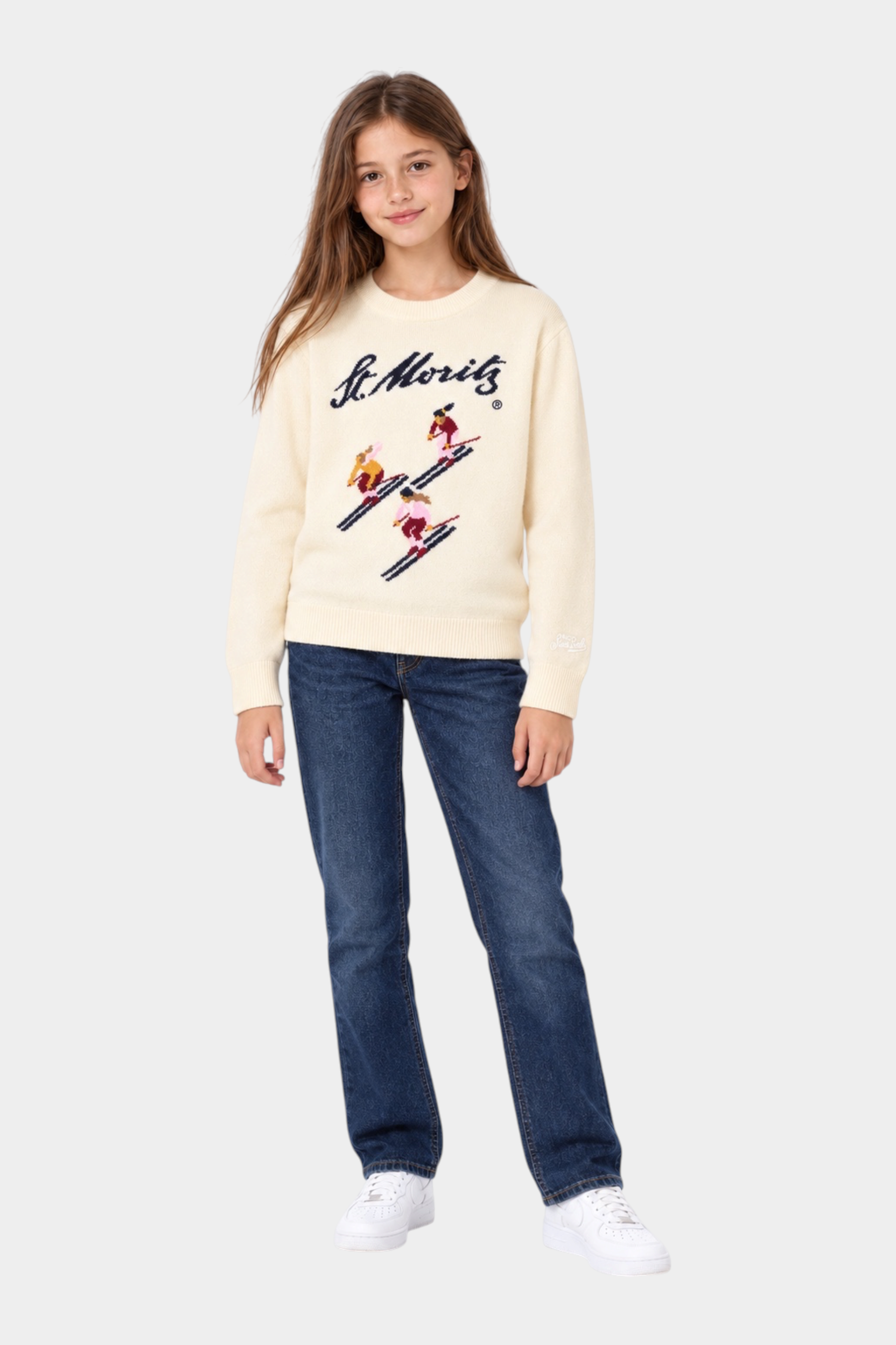 Bambina indossa maglia girocollo Follower SRL color avorio con intarsio sciatori St. Moritz e scritta blu navy