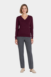 Modella indossa maglia bordeaux con scollo a V Ragno e pantaloni grigi eleganti, stile casual chic Follower SRL