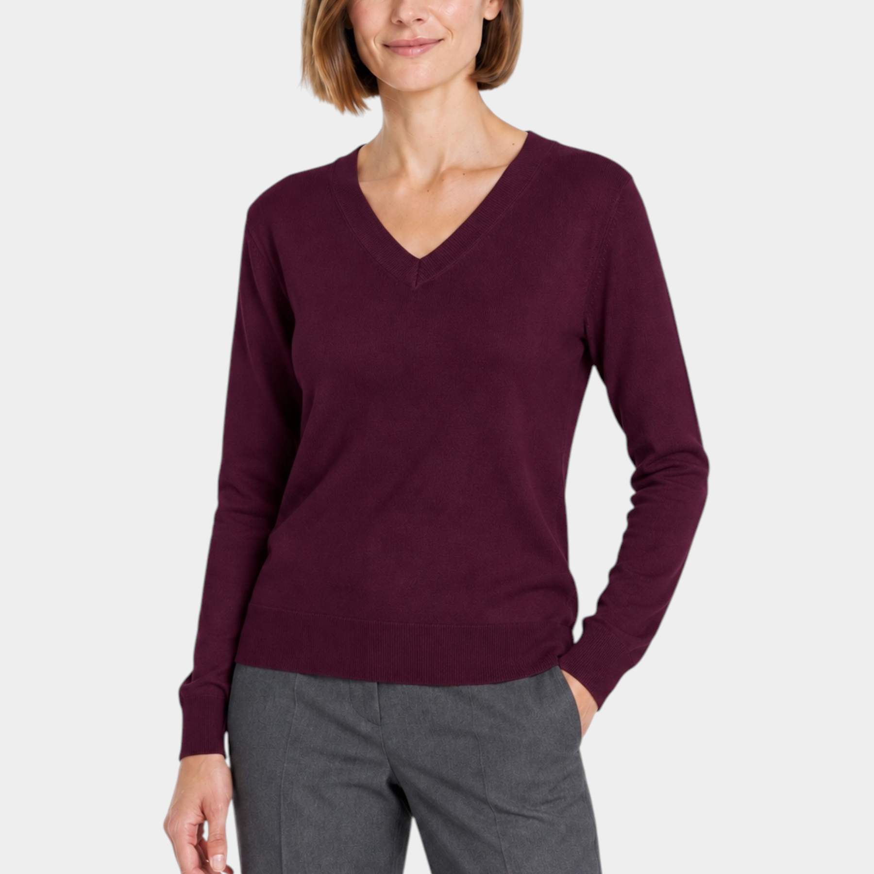 Donna indossa una maglia bordeaux con scollo a V del brand Follower SRL, abbinata a pantaloni grigi