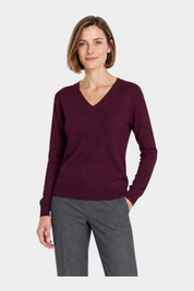 Donna indossa una maglia bordeaux con scollo a V del brand Follower SRL, abbinata a pantaloni grigi