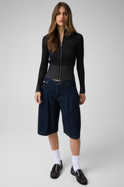 Modella indossa maglia Follower SRL GUESS full zip nera in misto lana a coste con maniche lunghe e vestibilità comoda