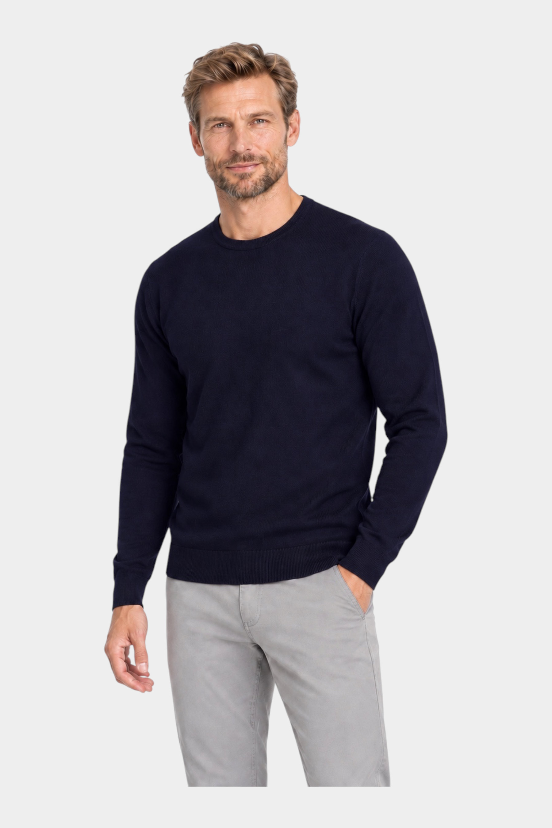 Modello indossa maglia girocollo in filo blu navy RAGNO proposta da Follower SRL con pantaloni grigi