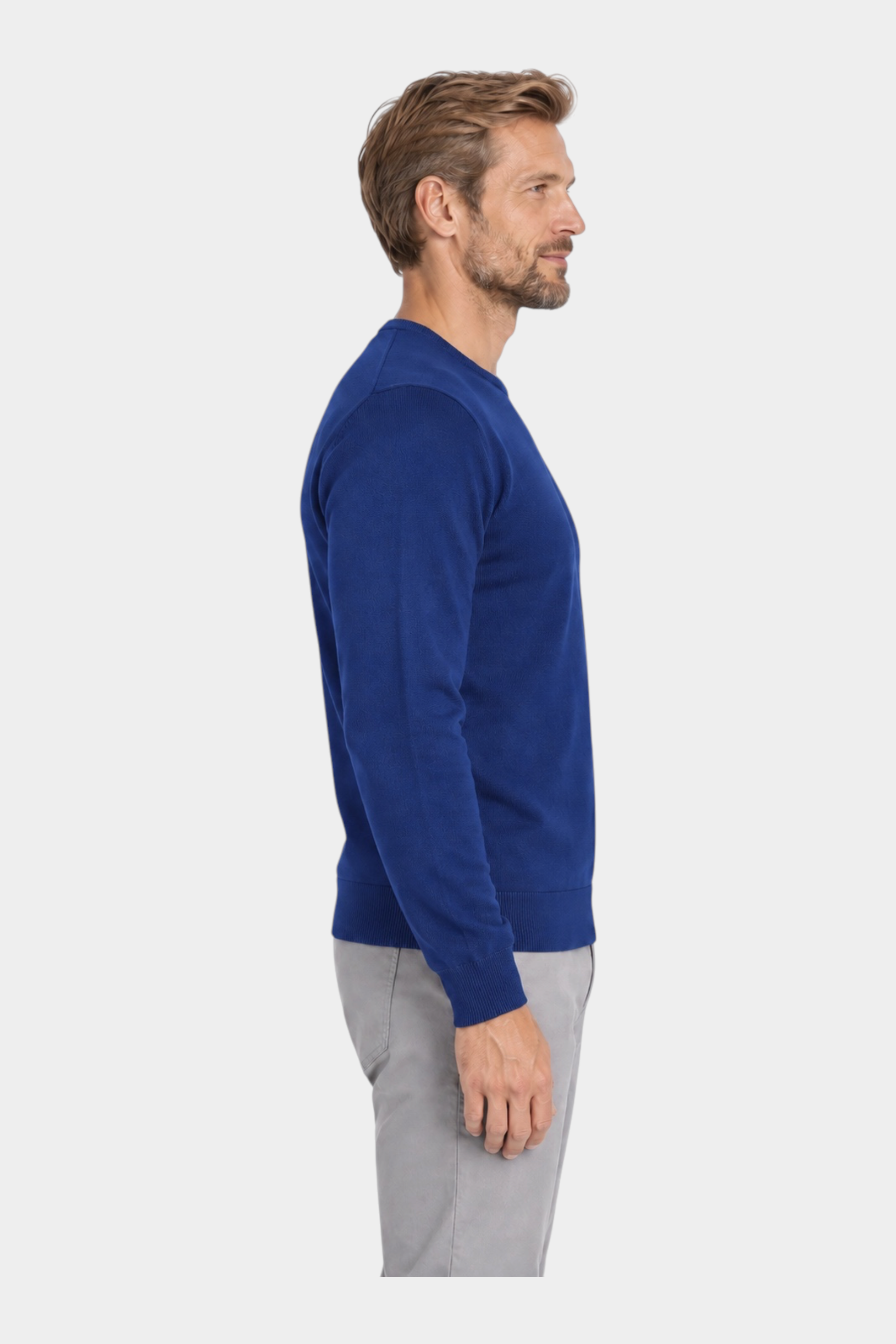 Modello di profilo indossa una maglia girocollo in filo blu di Follower SRL con pantaloni grigi su sfondo bianco