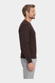 Modello indossa maglia girocollo marrone in filo di Follower SRL con pantaloni grigi, vista laterale