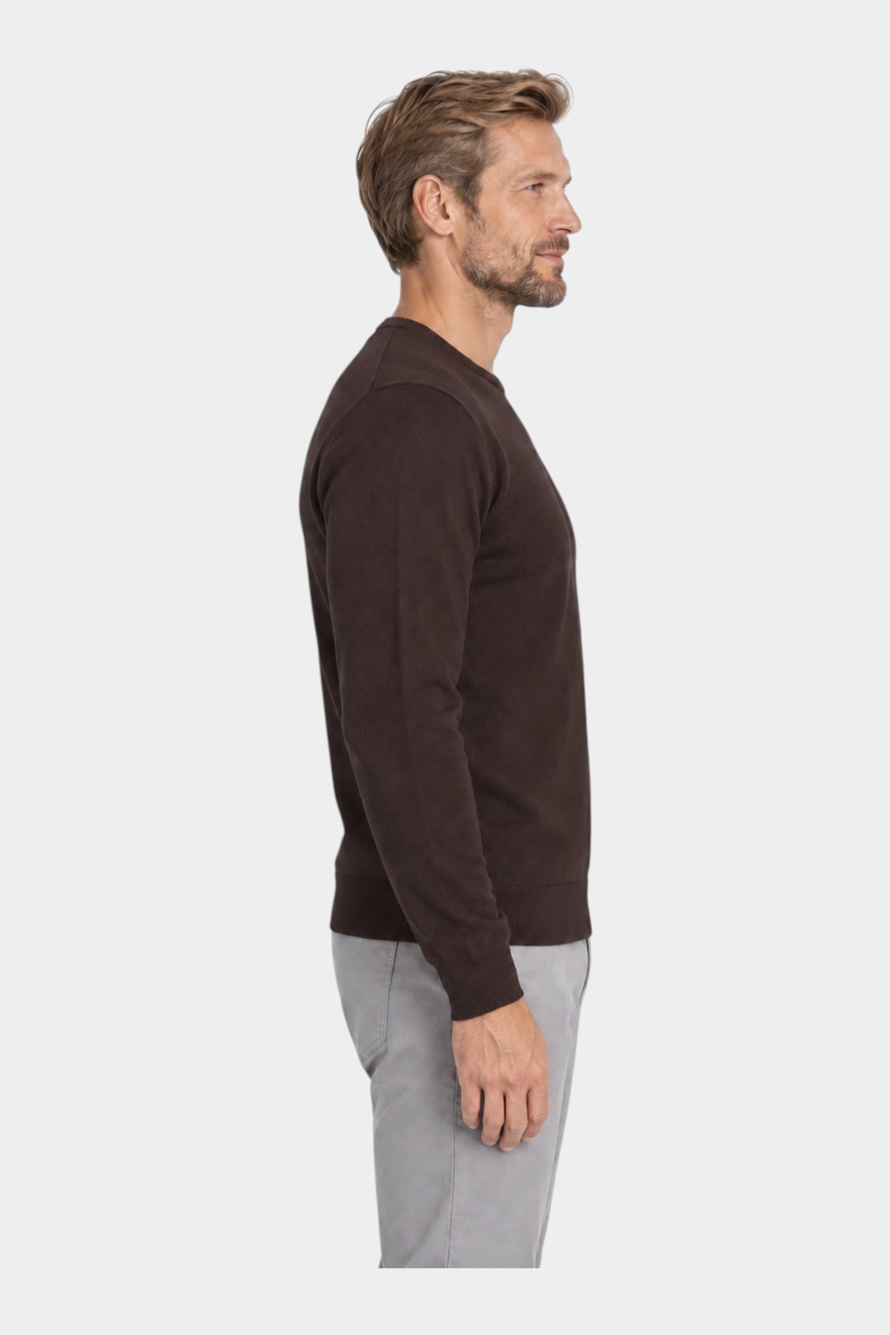Modello indossa maglia girocollo marrone in filo di Follower SRL con pantaloni grigi, vista laterale