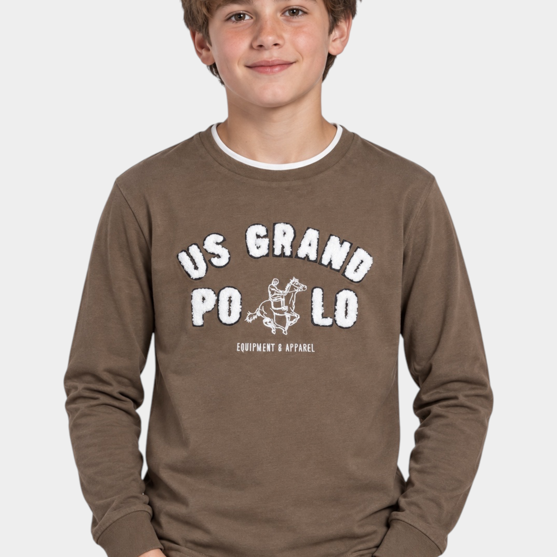 Ragazzo indossa una maglia girocollo marrone Follower SRL con maxi logo US GRAND POLO bianco e dettagli grafici