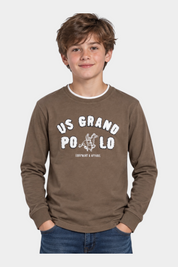 Ragazzo indossa una maglia girocollo marrone Follower SRL con maxi logo US GRAND POLO bianco e dettagli grafici