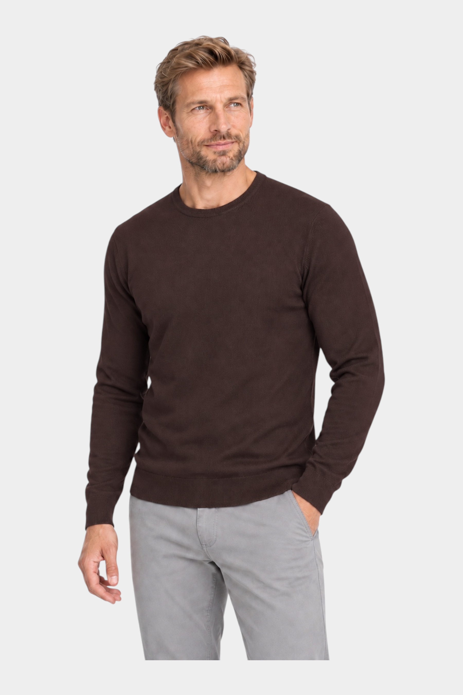 Modello indossa maglia girocollo marrone in filo di Follower SRL con pantaloni grigi su sfondo bianco