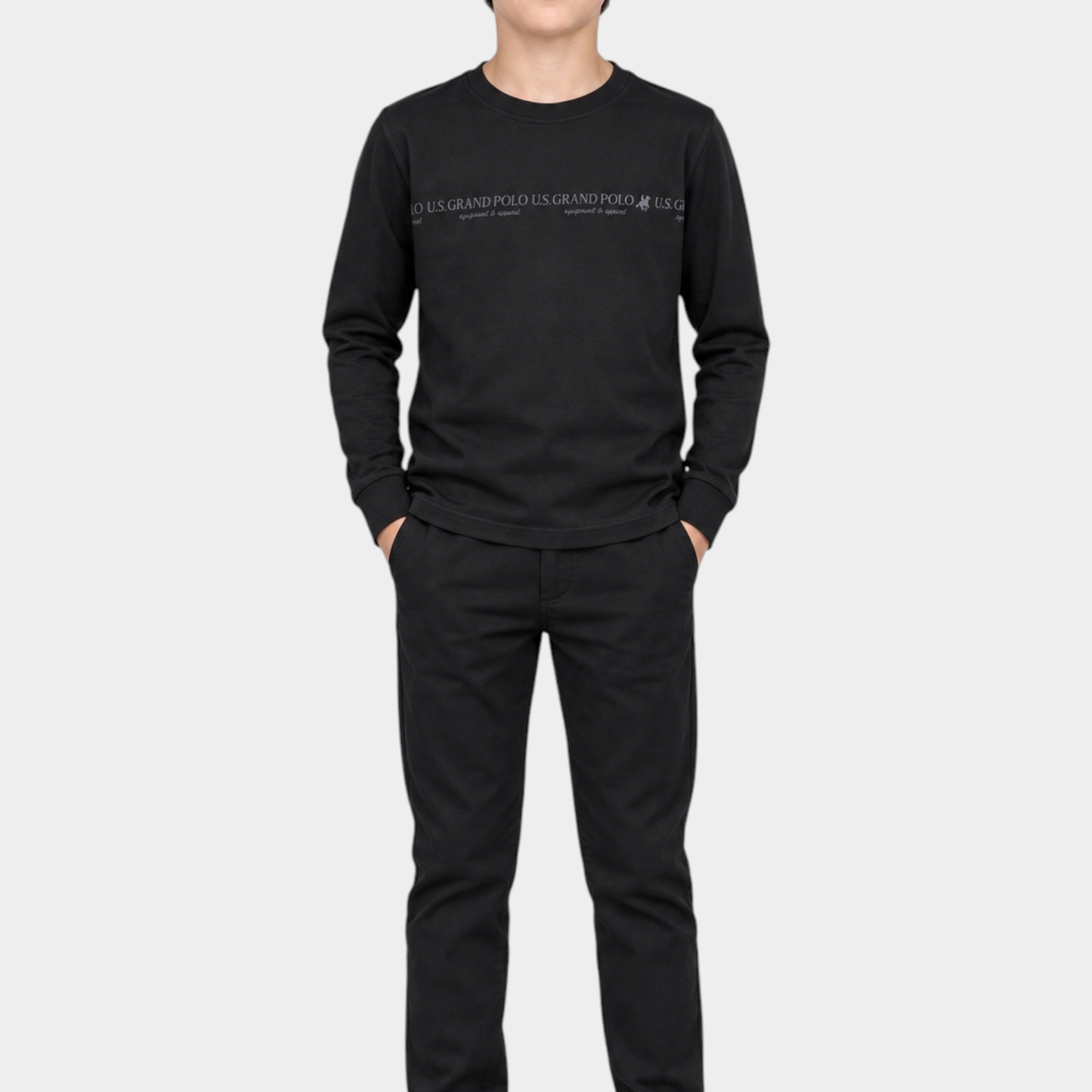 Ragazzo indossa maglia girocollo nera Follower SRL con logo US GRAND POLO e pantaloni neri abbinati