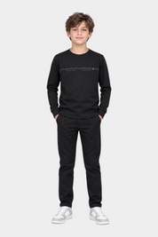 Ragazzo indossa maglia girocollo nera Follower SRL con logo US GRAND POLO e pantaloni neri abbinati