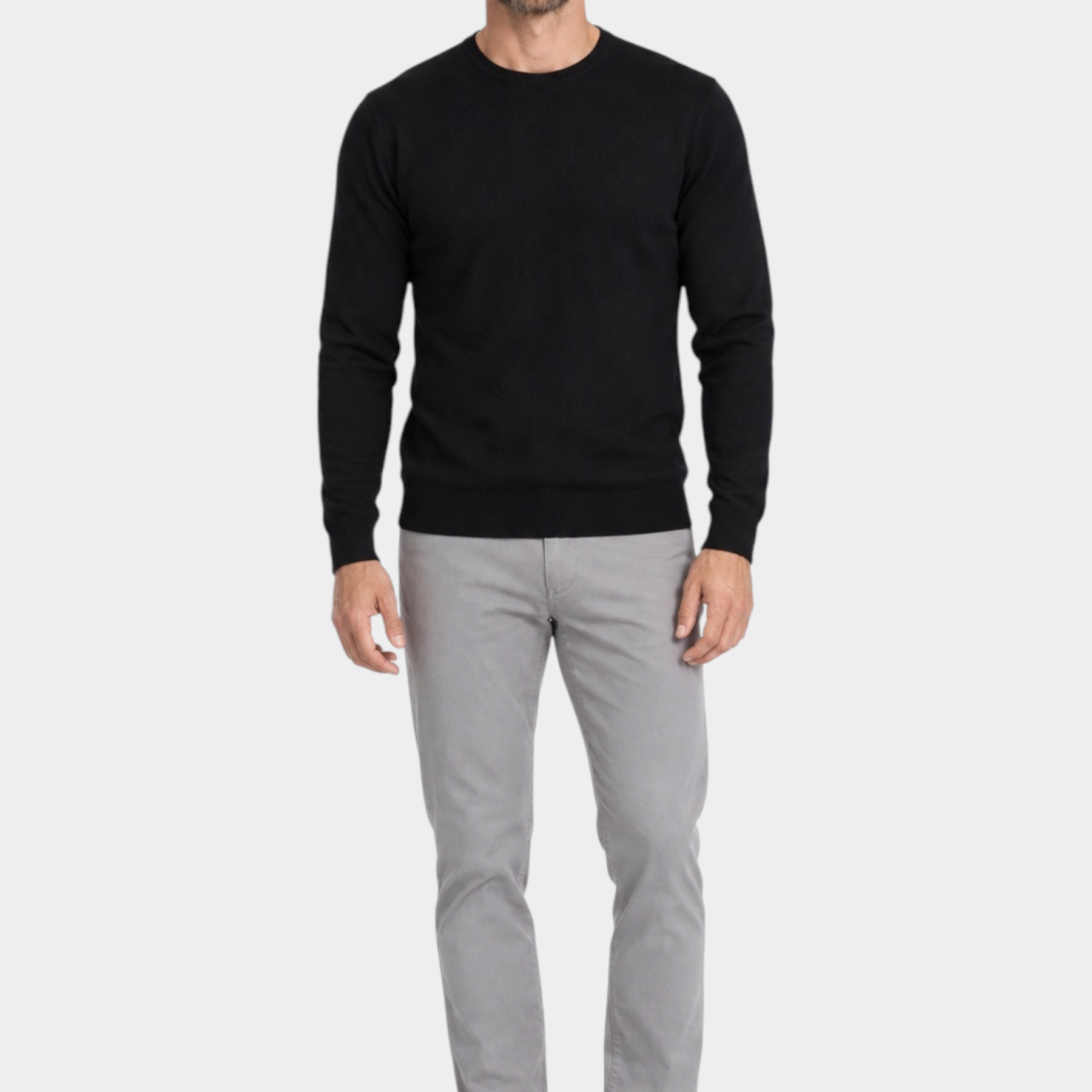Modello indossa maglia girocollo nera in filo Ragno con pantaloni grigi e scarpe eleganti Follower SRL