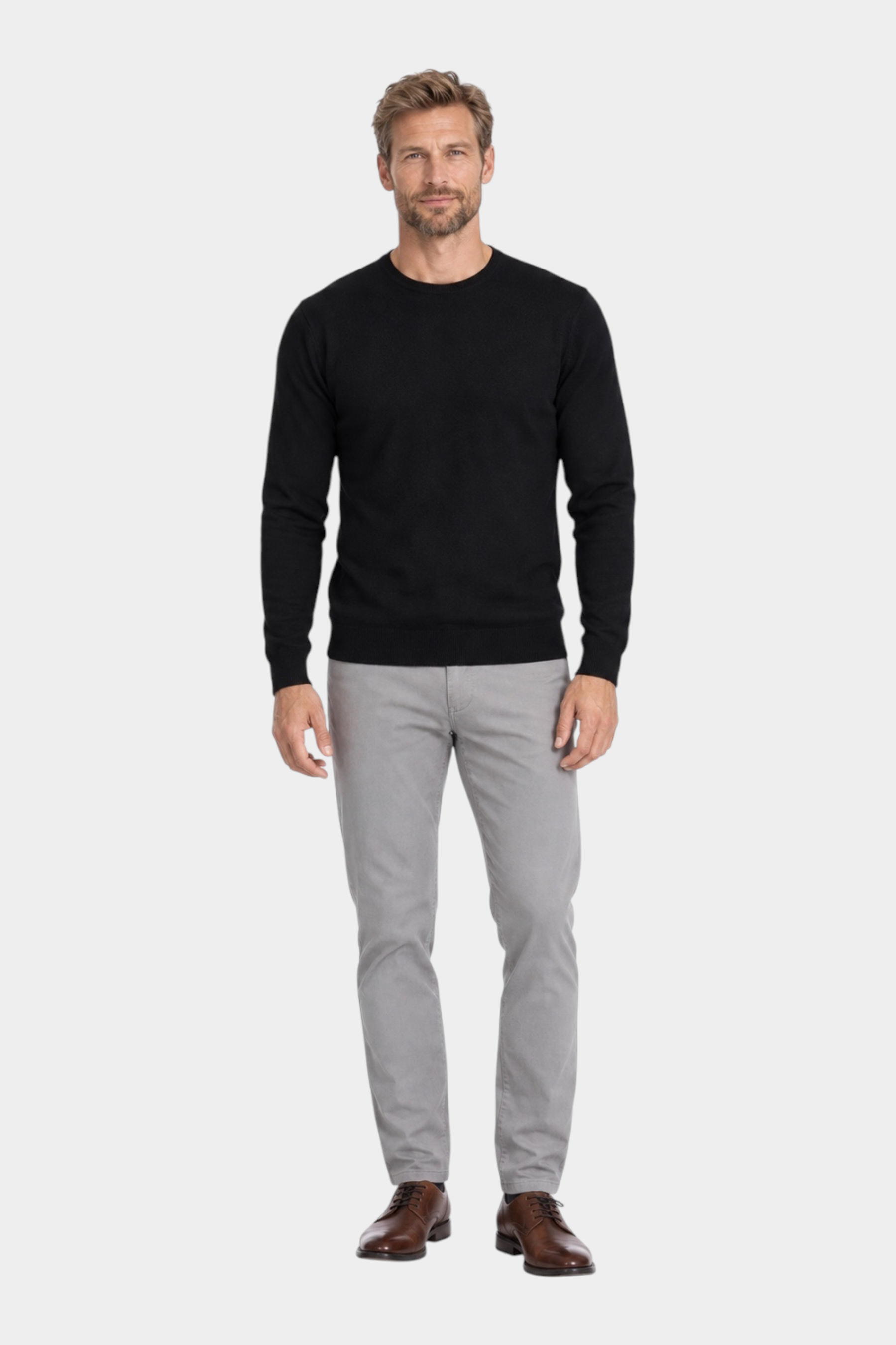 Modello indossa maglia girocollo nera in filo Ragno con pantaloni grigi e scarpe eleganti Follower SRL