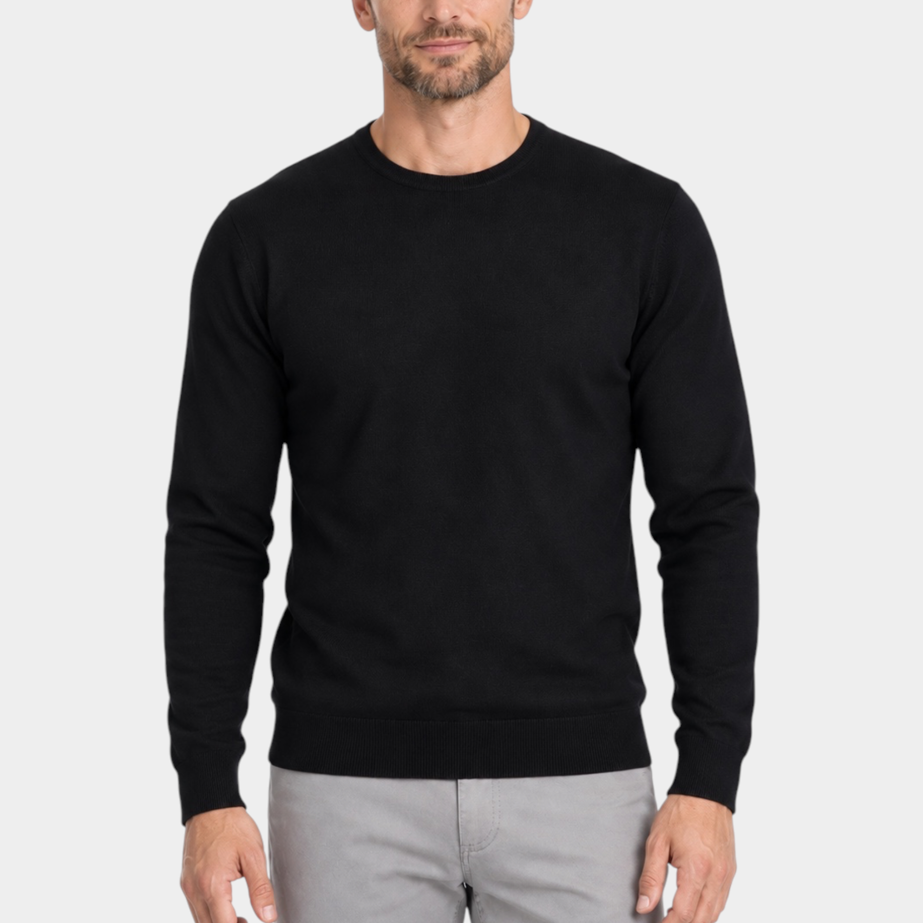 Modello indossa maglia girocollo nera in filo Ragno di Follower SRL con pantaloni grigi su sfondo bianco