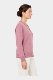 Modella di profilo indossa una maglia Follower SRL lilla con scollo a V e vestibilità boxy fit