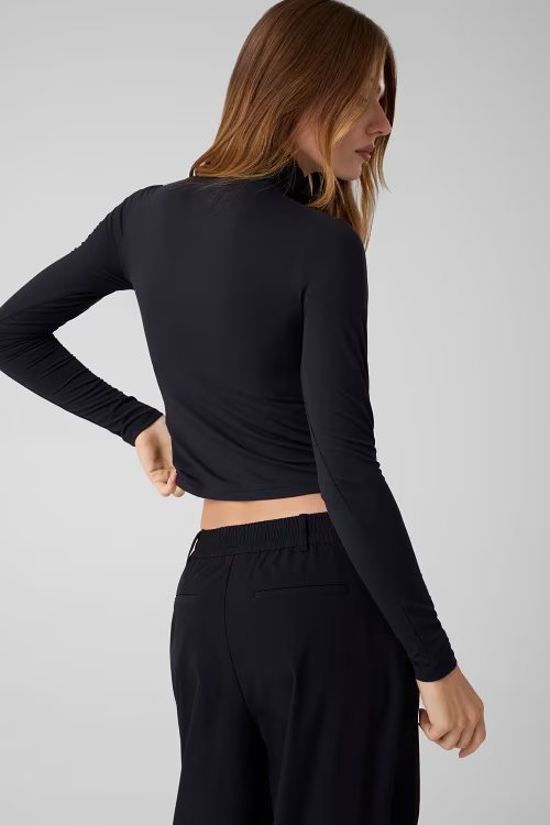 Modella indossa maglia lupetto nera in microfibra a maniche lunghe di Follower SRL, vista posteriore
