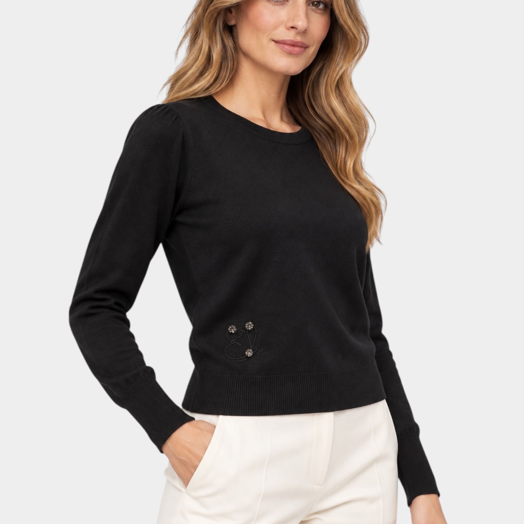 Modella indossa maglia in filo nera Follower SRL con girocollo, maniche lunghe e dettaglio floreale decorativo