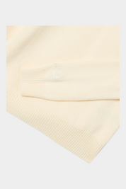Dettaglio della manica e del polsino a costine della maglia Follower SRL color panna per bambina