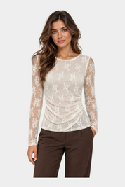 Modella indossa una maglia Follower SRL in pizzo avorio con maniche lunghe e dettaglio drappeggiato sul fianco
