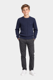 Ragazzo indossa maglione girocollo blu a trecce con logo Follower SRL e pantaloni scuri