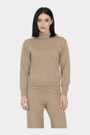 Modella indossa un maglione dolcevita beige a maniche lunghe di Follower SRL su sfondo neutro