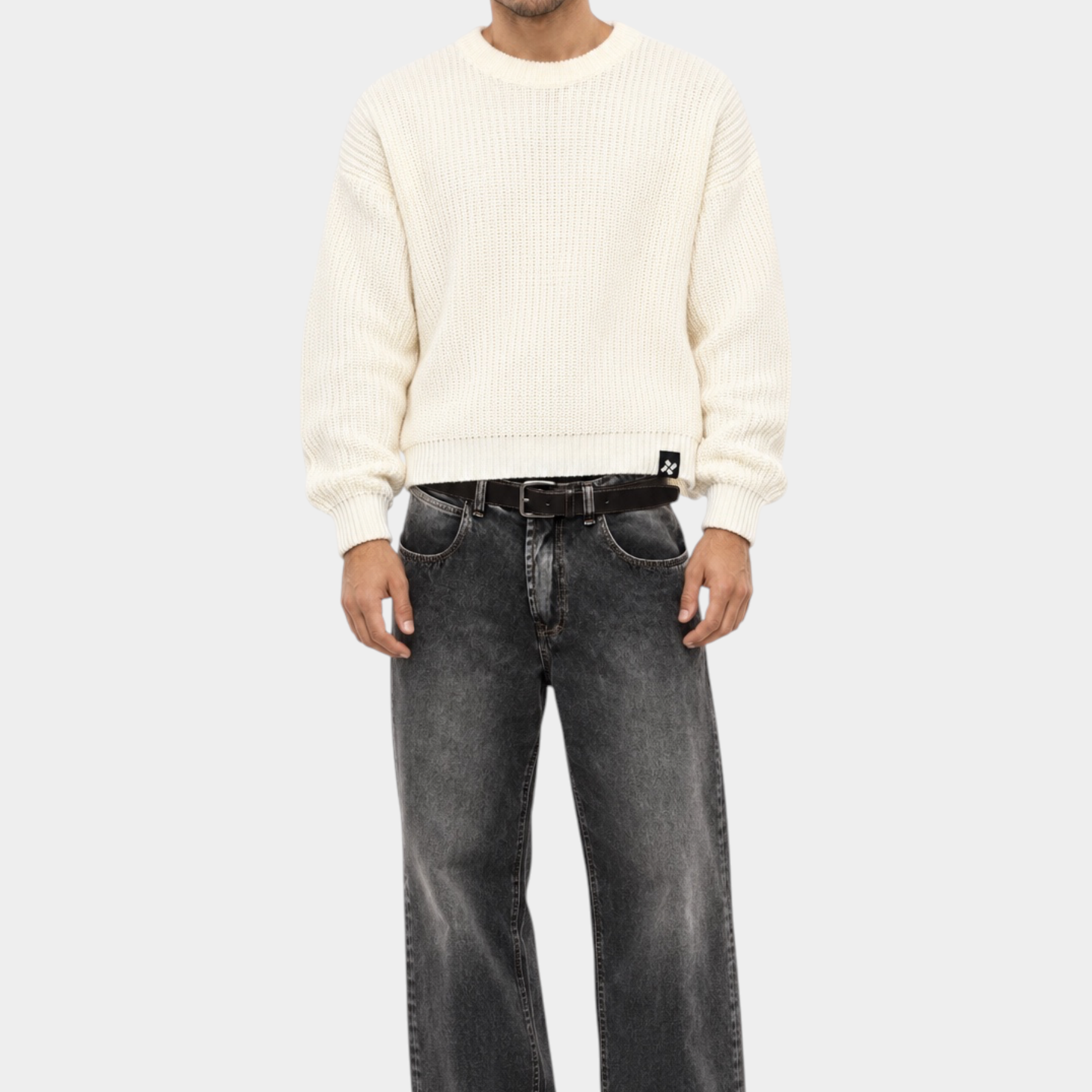 Maglione girocollo Follower SRL beige a maglia larga indossato da un modello con jeans grigi