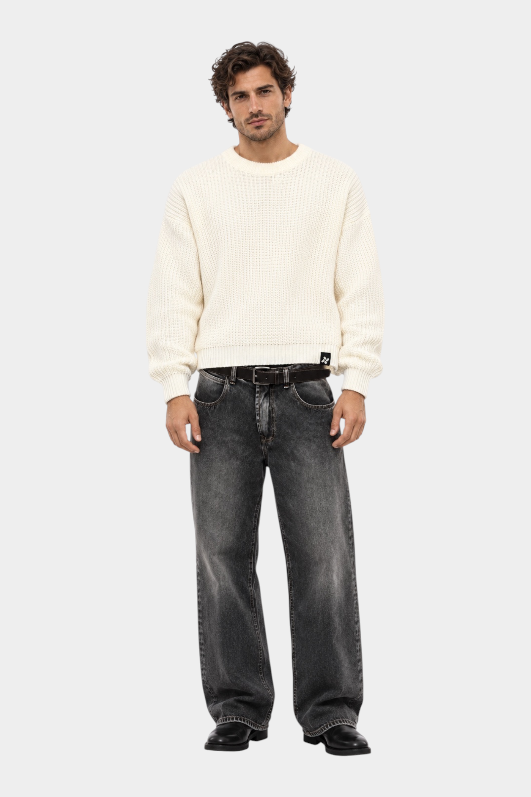 Maglione girocollo Follower SRL beige a maglia larga indossato da un modello con jeans grigi