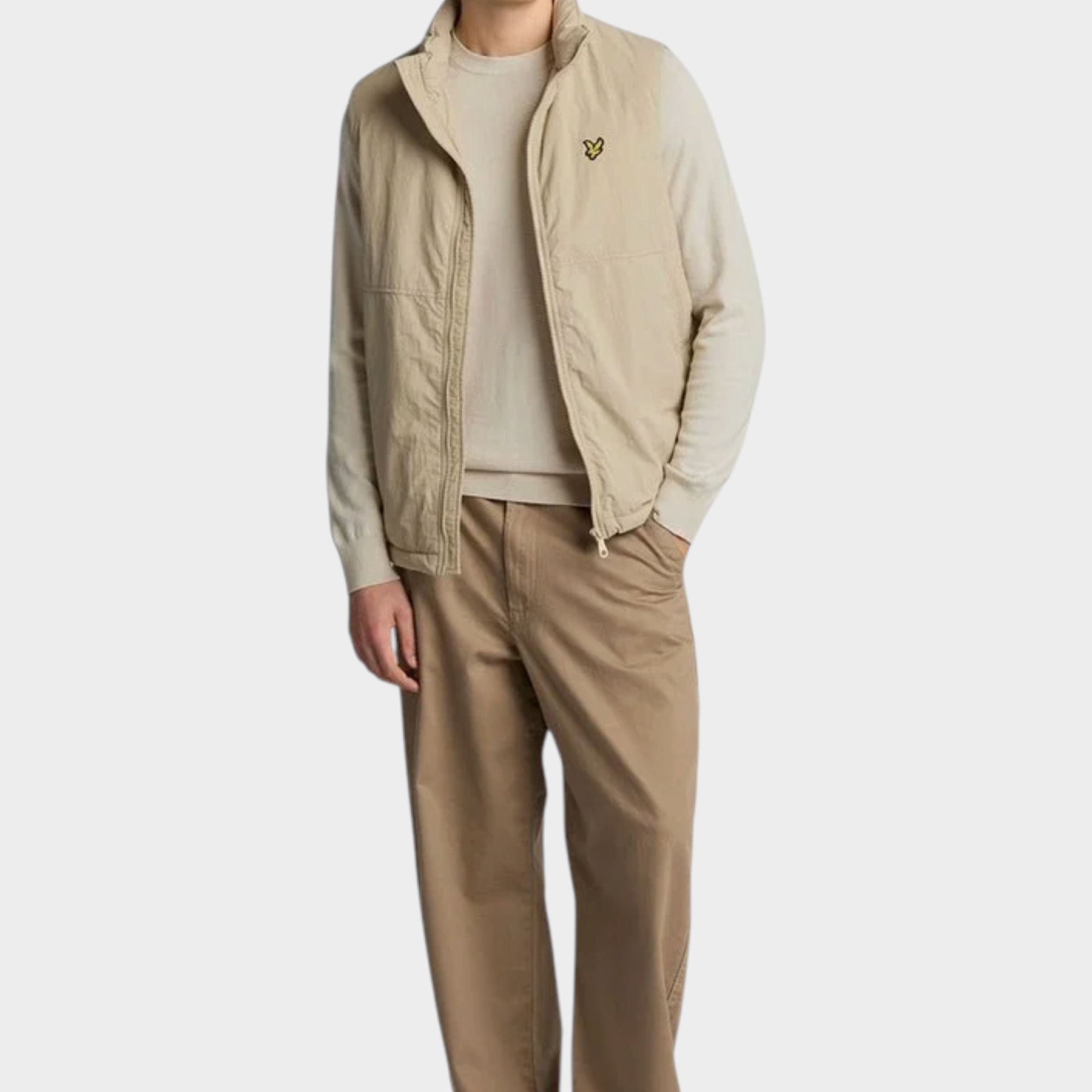 Modello Follower SRL indossa maglione girocollo beige in cotone e lana merino con gilet tecnico coordinato
