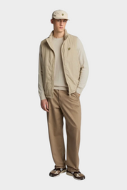 Modello Follower SRL indossa maglione girocollo beige in cotone e lana merino con gilet tecnico coordinato
