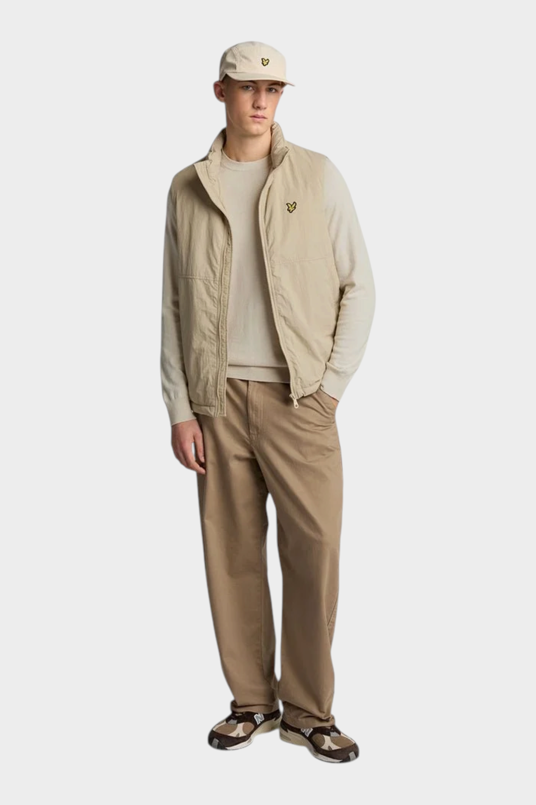 Modello Follower SRL indossa maglione girocollo beige in cotone e lana merino con gilet tecnico coordinato